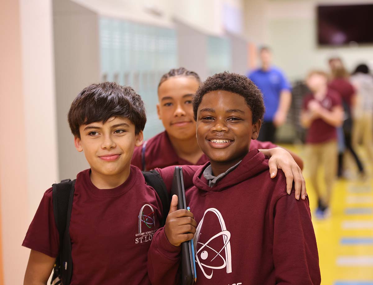 Elementary student smiling and posing together in a classroom.